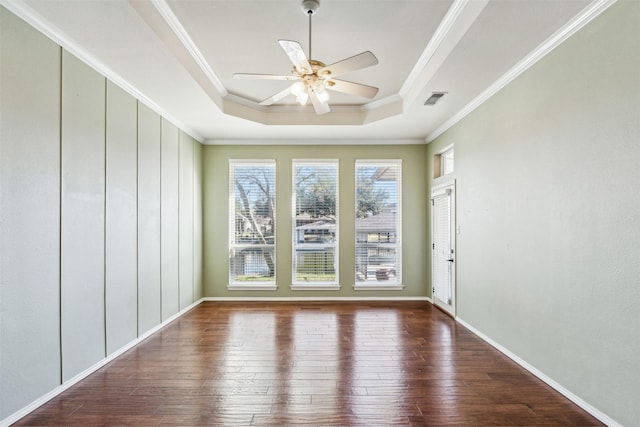 unfurnished room with a tray ceiling, crown molding, hardwood / wood-style floors, and ceiling fan