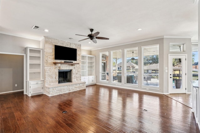 unfurnished living room with a healthy amount of sunlight, a stone fireplace, and dark hardwood / wood-style flooring