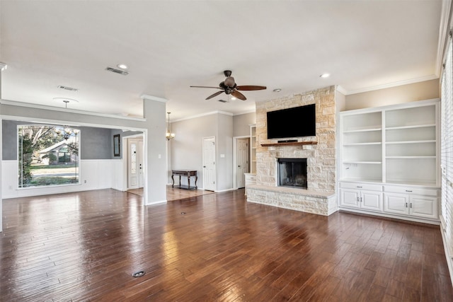 unfurnished living room with ceiling fan with notable chandelier, dark hardwood / wood-style flooring, ornamental molding, and a fireplace