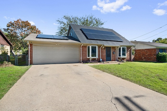 view of front of house featuring solar panels, a garage, and a front lawn