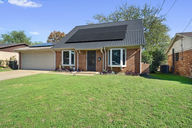 view of front of property featuring solar panels, a garage, cooling unit, and a front lawn