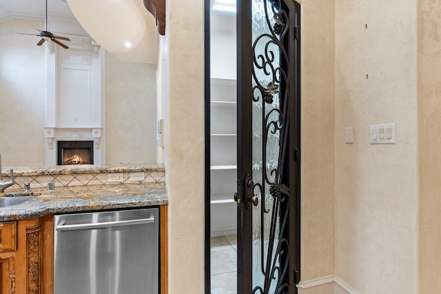 interior space featuring decorative backsplash, vanity, a fireplace, and ceiling fan