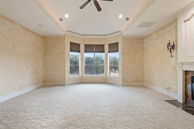 unfurnished living room featuring a high end fireplace, carpet, ceiling fan, and ornamental molding