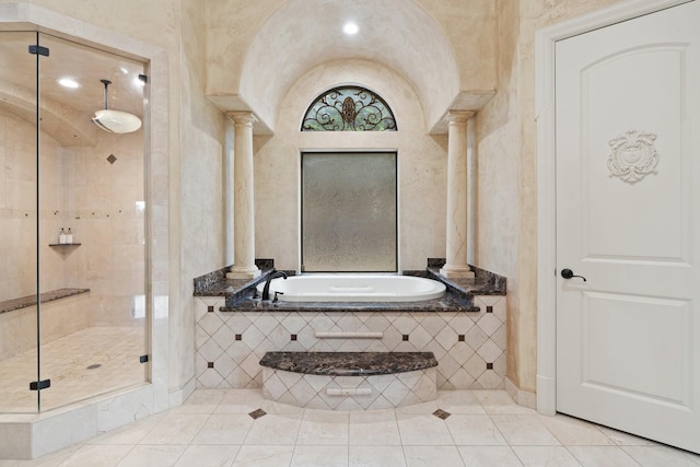 bathroom with decorative columns, tile patterned floors, and shower with separate bathtub