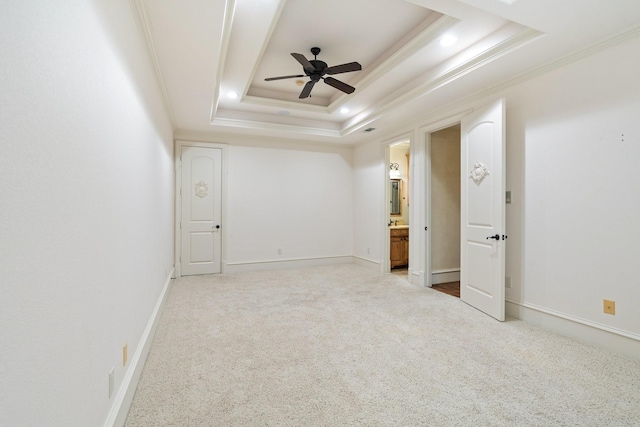 empty room featuring crown molding, ceiling fan, a raised ceiling, and light carpet