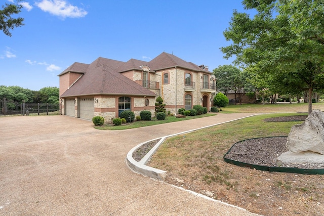 view of front of property with a garage, a balcony, and a front lawn