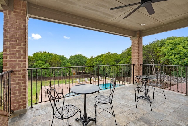 view of patio / terrace with ceiling fan and a fenced in pool