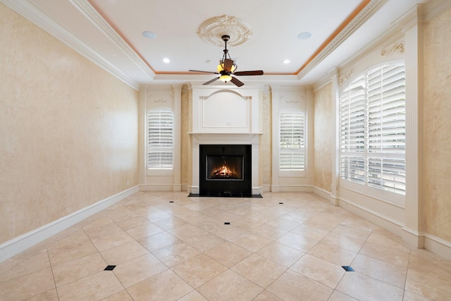 unfurnished living room with ceiling fan, light tile patterned flooring, a raised ceiling, and ornamental molding