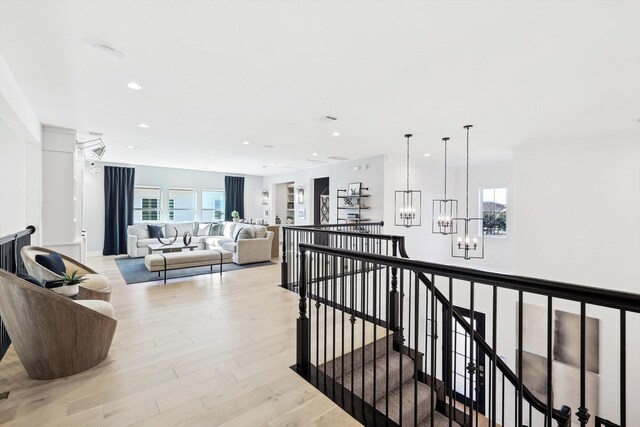 corridor featuring light hardwood / wood-style floors and a notable chandelier