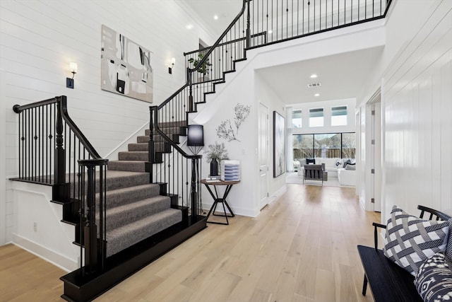 staircase with a high ceiling and hardwood / wood-style floors