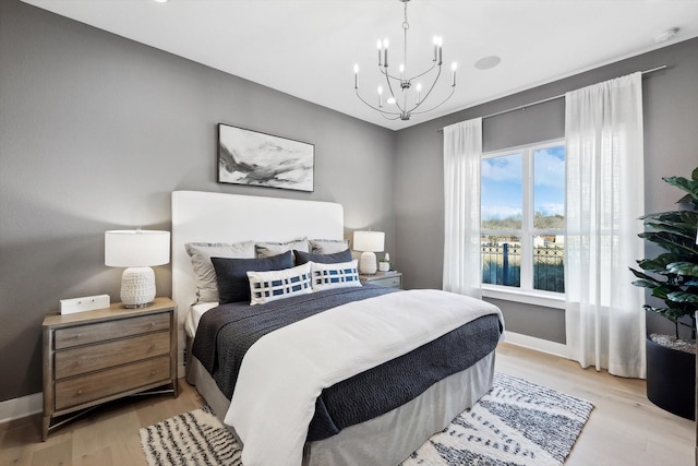 bedroom featuring light wood-type flooring and an inviting chandelier