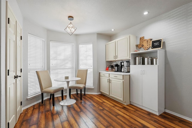 kitchen featuring dark hardwood / wood-style flooring, tasteful backsplash, and hanging light fixtures