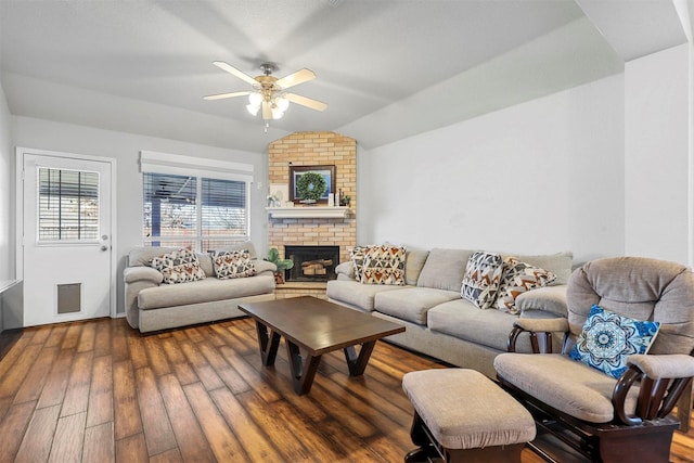 living room with ceiling fan, hardwood / wood-style flooring, lofted ceiling, and a brick fireplace