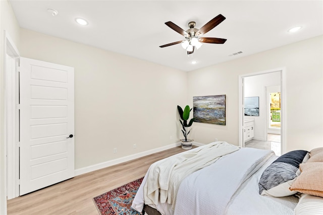 bedroom featuring ceiling fan, ensuite bathroom, and light wood-type flooring