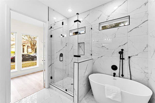 bathroom featuring shower with separate bathtub