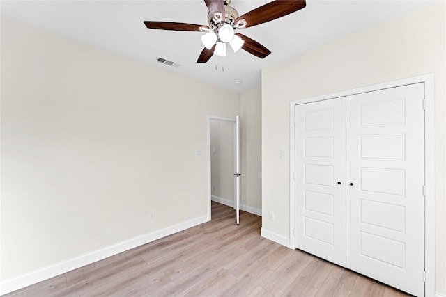 unfurnished bedroom featuring ceiling fan, light hardwood / wood-style floors, and a closet