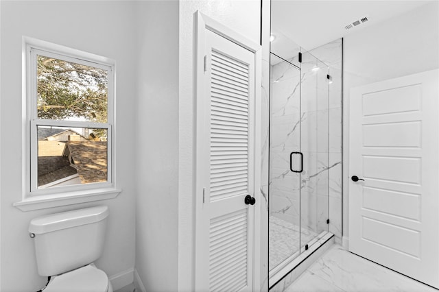 bathroom with a shower with door and toilet