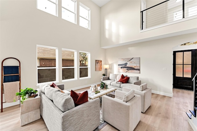 living room featuring a high ceiling and light hardwood / wood-style floors