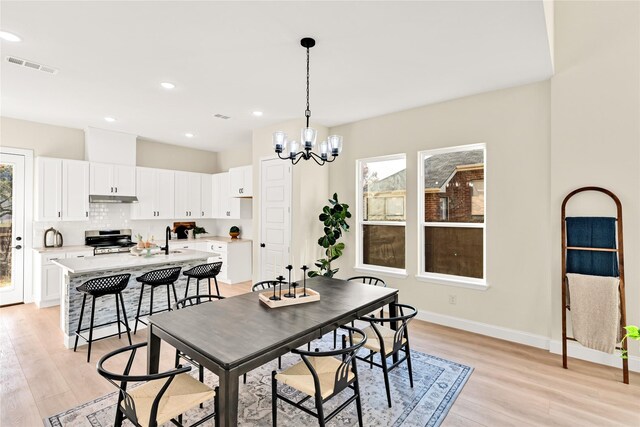 dining area with a chandelier, light hardwood / wood-style flooring, and a wealth of natural light