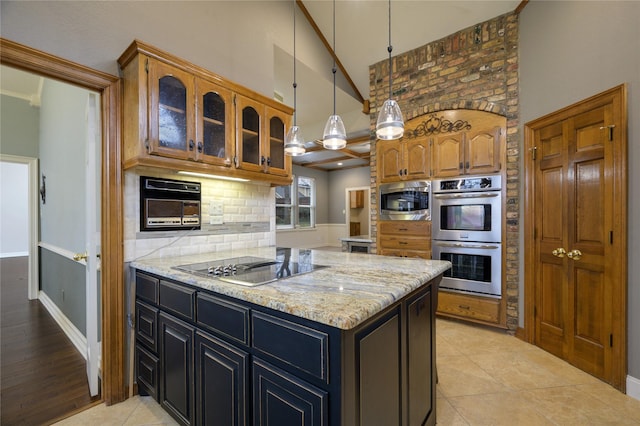 kitchen with light tile patterned flooring, light stone counters, and appliances with stainless steel finishes