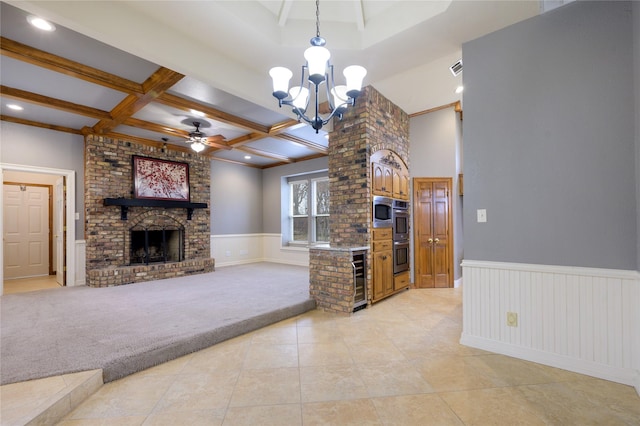 carpeted living room featuring coffered ceiling, ceiling fan with notable chandelier, wine cooler, a fireplace, and beamed ceiling