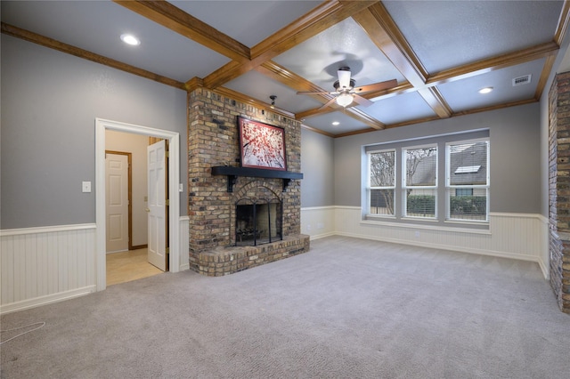 unfurnished living room with beam ceiling, light colored carpet, a brick fireplace, and coffered ceiling