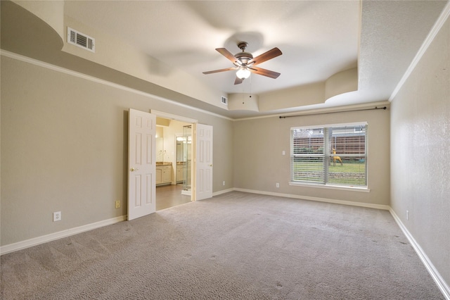 spare room with a tray ceiling, ceiling fan, and light colored carpet