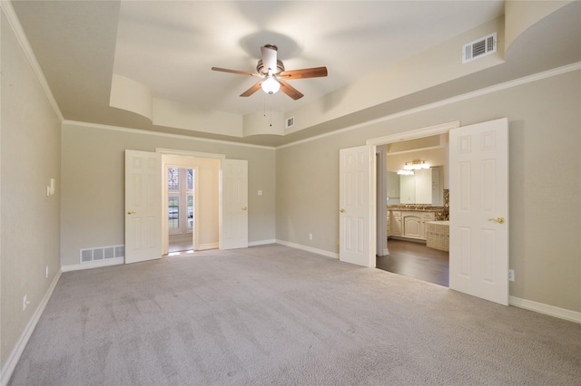 carpeted empty room featuring a tray ceiling, ceiling fan, and a towering ceiling