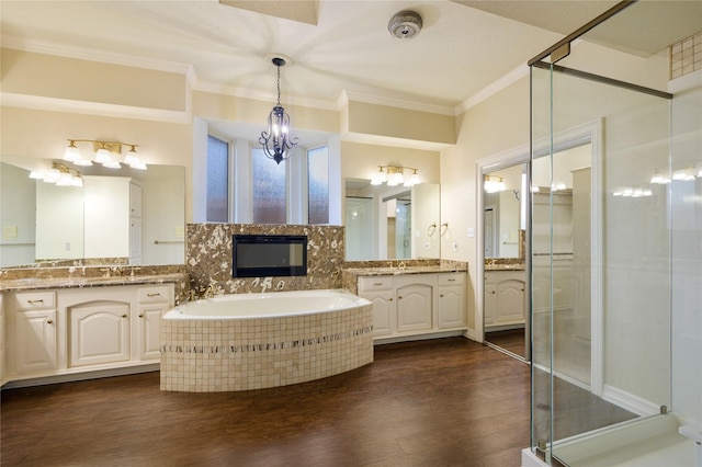 bathroom featuring plus walk in shower, vanity, wood-type flooring, and ornamental molding