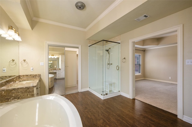 bathroom with crown molding, hardwood / wood-style floors, vanity, and an enclosed shower