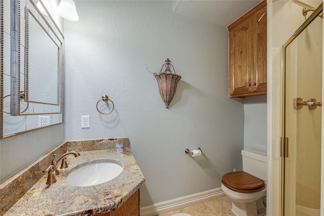 bathroom featuring tile patterned flooring, vanity, toilet, and a shower with door