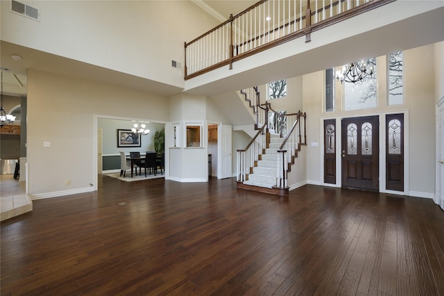 entrance foyer featuring a chandelier, a high ceiling, dark hardwood / wood-style floors, and a wealth of natural light