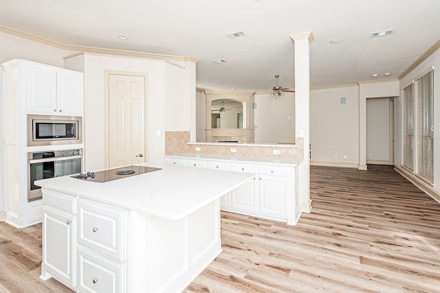 kitchen featuring white cabinetry, ceiling fan, a center island, and stainless steel appliances