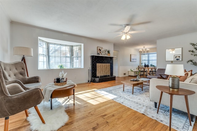 living room with a notable chandelier, a fireplace, and light hardwood / wood-style flooring