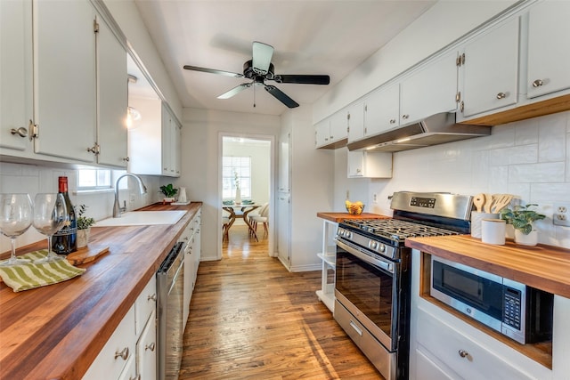 kitchen featuring white cabinetry, sink, stainless steel appliances, wood counters, and backsplash