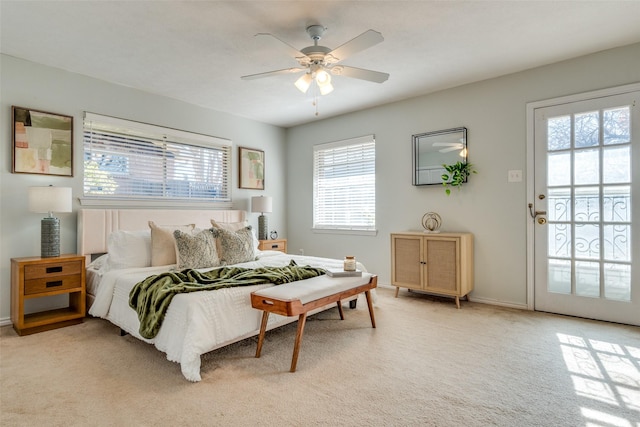 bedroom featuring ceiling fan, access to exterior, light carpet, and multiple windows