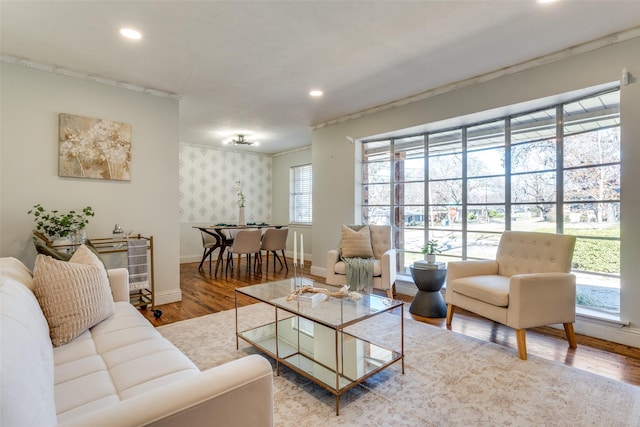 living room with ornamental molding and light hardwood / wood-style flooring