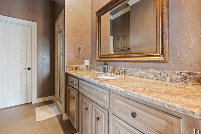 bathroom with a shower with door, tile patterned floors, and vanity