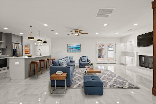 living room with recessed lighting, visible vents, a large fireplace, and ceiling fan