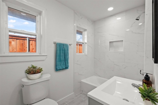 full bathroom with vanity, tiled shower / bath combo, toilet, and plenty of natural light