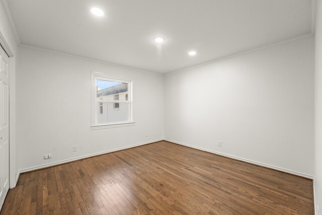 spare room with hardwood / wood-style floors and crown molding