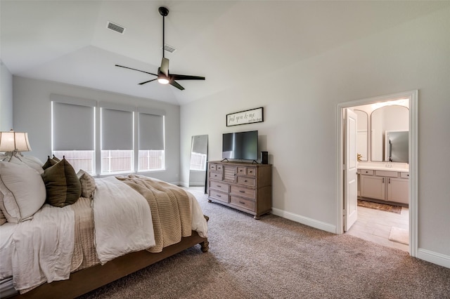 carpeted bedroom with connected bathroom, ceiling fan, and vaulted ceiling