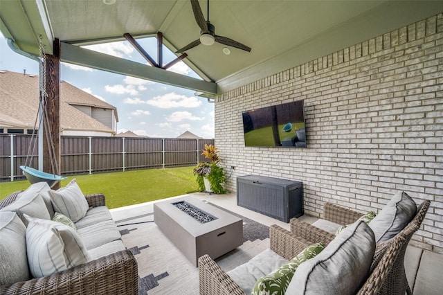 view of patio / terrace featuring ceiling fan and an outdoor living space with a fire pit