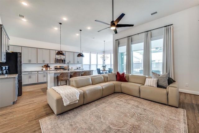 living room with light hardwood / wood-style floors and ceiling fan