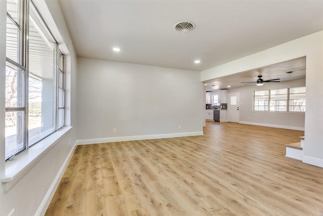 unfurnished living room featuring ceiling fan and light hardwood / wood-style flooring