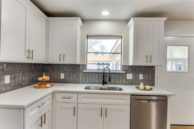 kitchen with dishwasher, sink, white cabinets, and backsplash