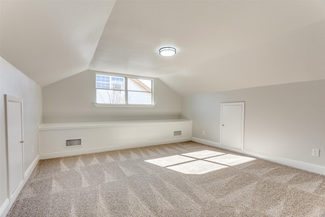 additional living space with vaulted ceiling and light carpet