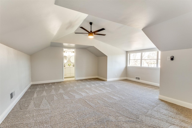 additional living space featuring vaulted ceiling, light colored carpet, and ceiling fan