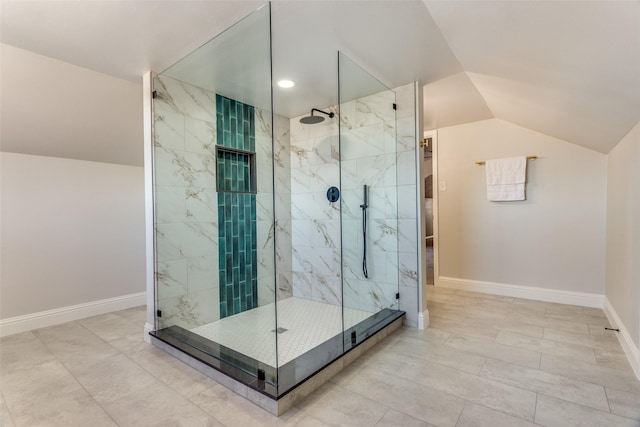 bathroom featuring vaulted ceiling and tiled shower