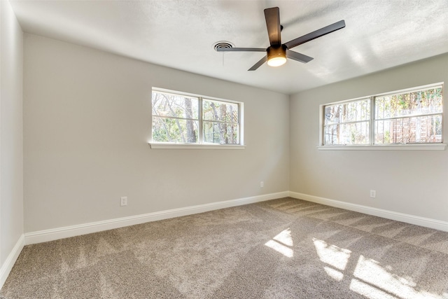 spare room featuring ceiling fan, carpet floors, and a healthy amount of sunlight